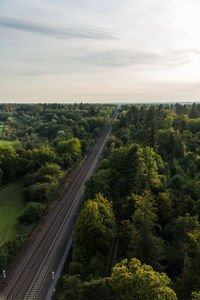 High angle view of road amidst trees against sky