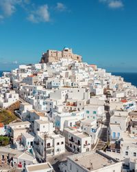 Drone high angle view of townscape of greek island astypalaia in aegean against blue sky