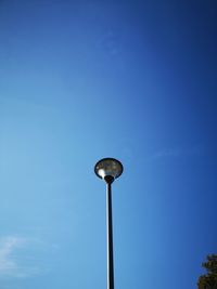 Low angle view of street light against blue sky