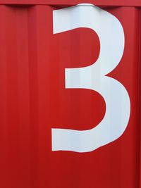 Close-up of number on red wall