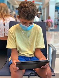 Boy with facemask looking at tablet