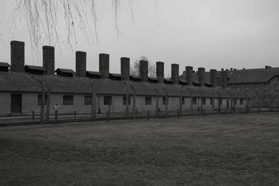 Buildings on field against clear sky