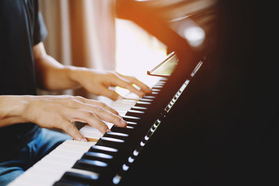 Midsection of man playing piano