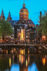 Church of st nicholas over old town canal illuminated at night in amsterdam, netherlands 
