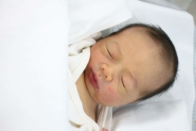 Portrait of cute baby sleeping on bed