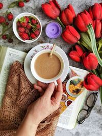 High angle view of hand holding coffee cup on table