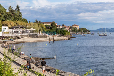 Scenic view of sea by buildings against sky