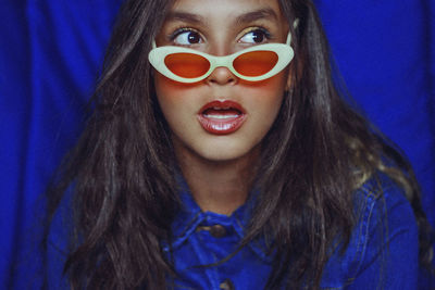 Close-up of shocked woman wearing sunglasses