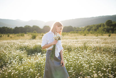 Woman holding flowers in field
