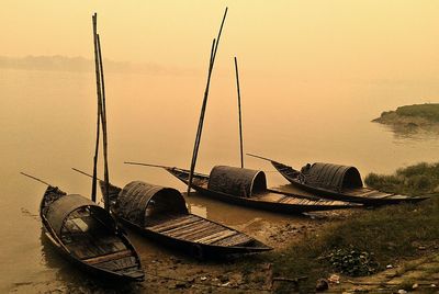 Boats in sea at sunset