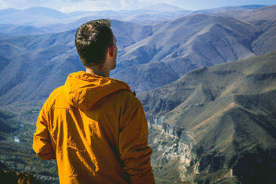 Rear view of man standing against mountains