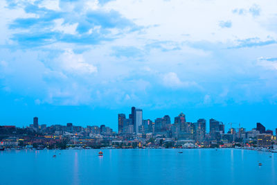 Sea by buildings against sky