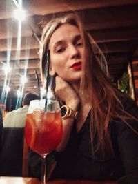 Portrait of woman drinking glass in restaurant