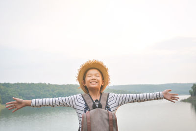 Smiling boy standing against sky