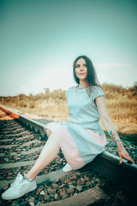 Portrait of young woman sitting on field