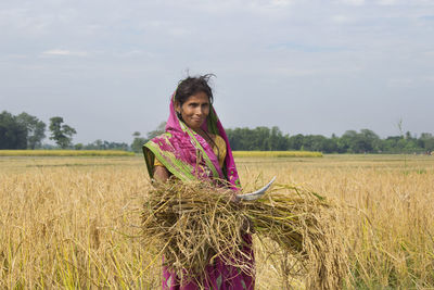 Portrait of indian woman farmer in rice paddy field