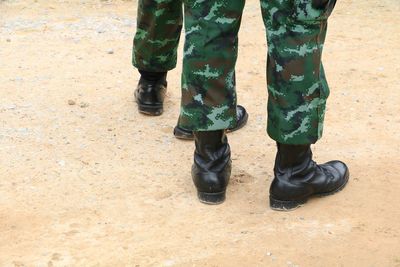 Low section of men standing on land