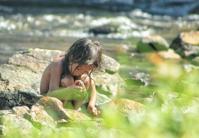 Full length of shirtless boy in water