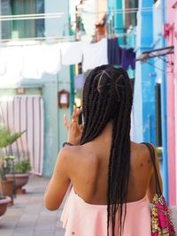 Rear view of woman standing on footpath