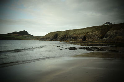 Scenic view of beach and mountains against sky