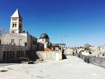 Historic buildings in town against clear blue sky