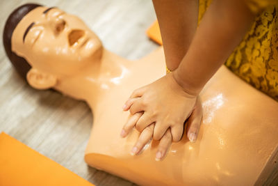 Cropped hands practicing on cpr dummy