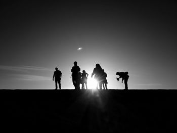 Silhouette people against sky during sunset