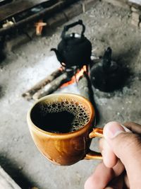 High angle view of hand holding coffee cup