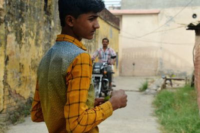 Close-up of boy standing on road in village