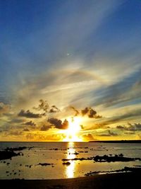 Scenic view of sea against dramatic sky during sunset