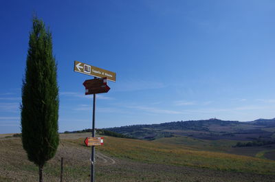 Low angle view of road sign against blue sky