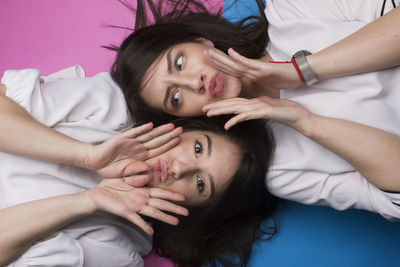 Portrait of young woman with friend lying down