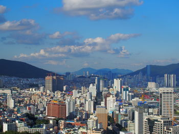Aerial view of buildings in city against sky