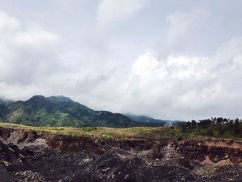 Scenic view of mountains against cloudy sky