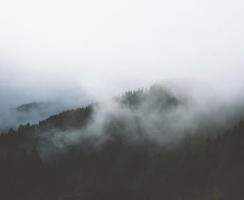 Scenic view of foggy weather against sky