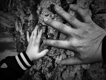 Son with father with hands on bark
