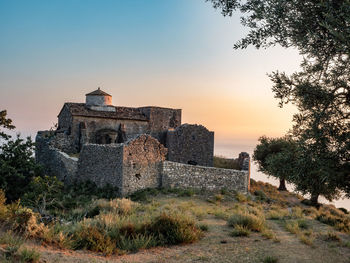 Old monastery against sky during sunset