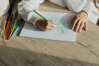 Girl drawing a picture at table