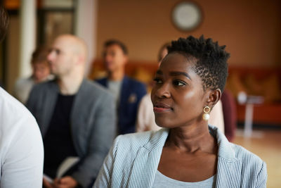 Female entrepreneur looking away while attending office seminar at workplace