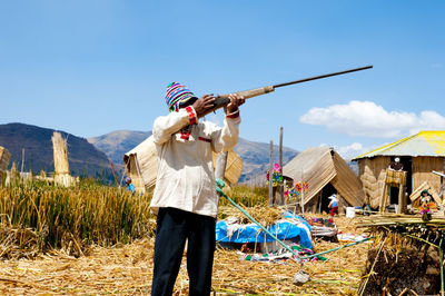 Woman with umbrella standing on field