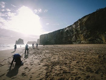 People standing at beach against sky