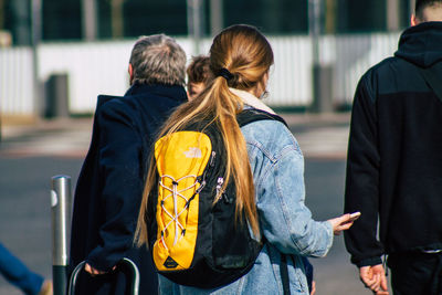 Rear view of people walking on street in city