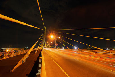 Light trails on road against sky at night