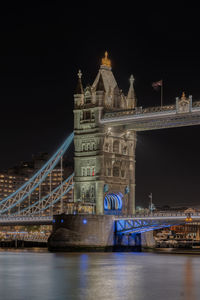 Illuminated bridge over river at night