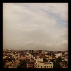 Cityscape against cloudy sky