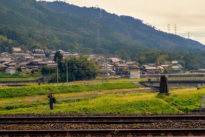 Railroad track amidst field against sky