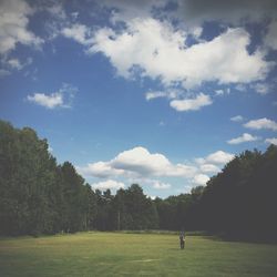 Scenic view of grassy field against cloudy sky