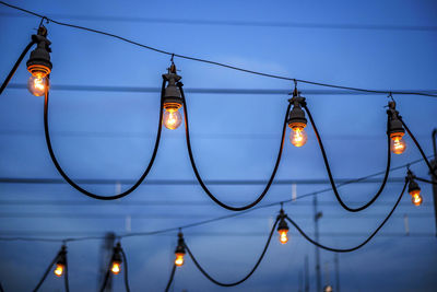 Low angle view of illuminated street light against sky