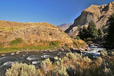 Scenic view of rocks and mountains against clear sky