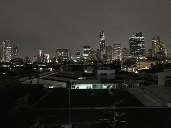 Illuminated buildings in city against sky at night